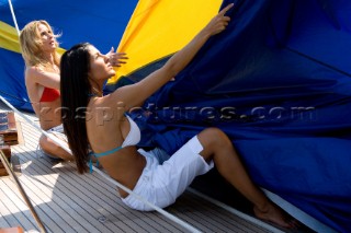 Glamorous female lifestyle model onboard a sailing yacht in the Mediterranean