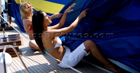 Glamorous female lifestyle model onboard a sailing yacht in the Mediterranean