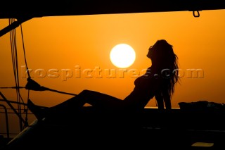 Glamorous female lifestyle model onboard a sailing yacht in the Mediterranean