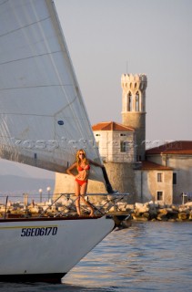 Glamorous female lifestyle model onboard a sailing yacht in the Mediterranean