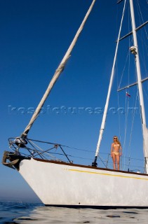 Glamorous female lifestyle model onboard a sailing yacht in the Mediterranean