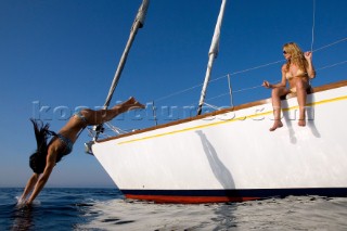 Glamorous female lifestyle model onboard a sailing yacht in the Mediterranean