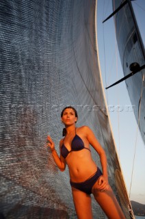 Glamorous female lifestyle model onboard a sailing yacht in the Mediterranean