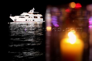 Benetti superyacht moored at anchor at night for social event