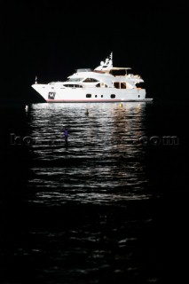 Benetti superyacht moored at anchor at night for social event