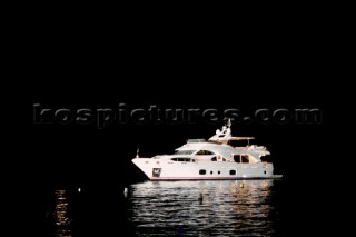 Benetti superyacht moored at anchor at night for social event