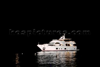 Benetti superyacht moored at anchor at night for social event