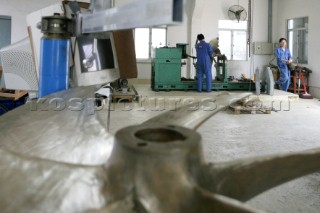 Yacht builders and skilled workers boatbuilding at the Cheoy Lee shipyard and boatbuilders in China. Manufacturing propellers.