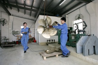 Yacht builders and skilled workers boatbuilding at the Cheoy Lee shipyard and boatbuilders in China. Manufacturing propellers.