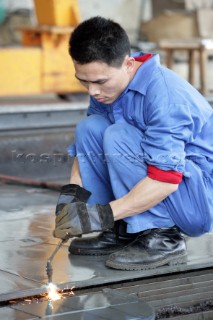 Yacht builders and skilled workers boatbuilding at the Cheoy Lee shipyard and boatbuilders in China. Welders.