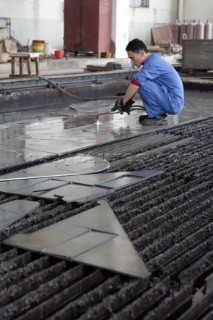 Yacht builders and skilled workers boatbuilding at the Cheoy Lee shipyard and boatbuilders in China. Welders welding.