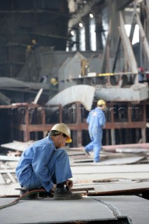 Yacht builders and skilled workers boatbuilding at the Cheoy Lee shipyard and boatbuilders in China. Welders welding.