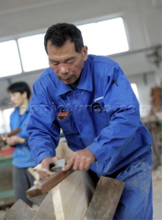 Yacht builders and skilled workers boatbuilding at the Hansheng shipyard and boatbuilders in China