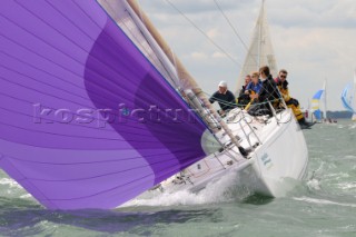 downwind sailing J122 asymmetric sails set sailing Cowes Week Isle of Wight crew on the port side