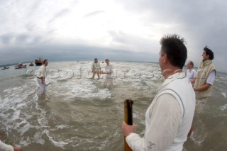 THE SOLENT, UK - August 31st: For a briefÊspellÊonce each summer on the lowest of spring tides, members of the Island Sailing Club and Royal Southern Yacht Club sail outÊto The Brambles sand bank in the middle of The Solent andÊplay cricket, before the tide rushes back in one hour later.ÊThe fixture was first started in the 1950Õs by the late Uffa Fox, a sailing companion of the Duke of Edinburgh, the Royal Southern and the Island Sailing Club compete every year. As soon as the sandbank appears the stumps are put up and the match gets under way. Many of the competitors dress all in cricket whites and ÔThe Bramble InnÕ is erected to serve drinks to spectators. The Bramble Inn is one of the most bizarre pubs in England: it is in the middle of the sea and exists only for about an hour each year.