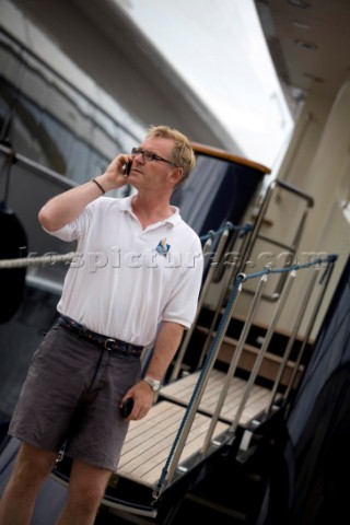 Crew using mobile telephone communication onboard superyacht   MODEL RELEASED 