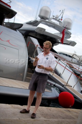 Crew using mobile telephone communication onboard superyacht   MODEL RELEASED 