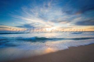 Colourful sunset over a sandy beach.