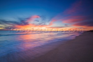 Colourful sunset over a sandy beach.