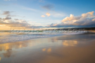 Colourful sunset over a sandy beach.