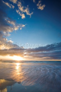 Colourful sunset over a sandy beach.