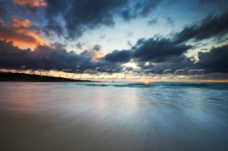 Colourful sunset over a sandy beach.