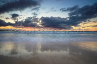 Colourful sunset over a sandy beach.