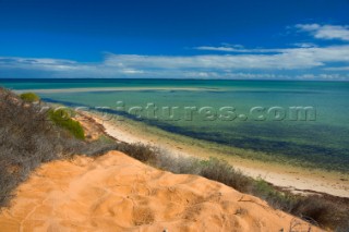 Striking red sand dunes by the sea.