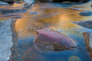 Slow exposure of a colourful stream running over the rocks of an impressive gorge