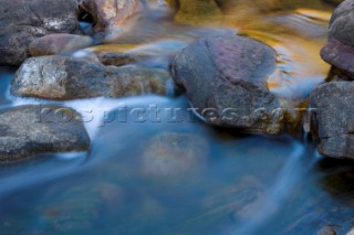 Slow exposure of a colourful stream running over the rocks of an impressive gorge