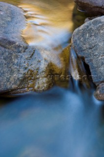 Slow exposure of a colourful stream running over the rocks of an impressive gorge