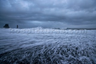 An angry stromy sea crashes against the volcanic shore near Vik, Iceland