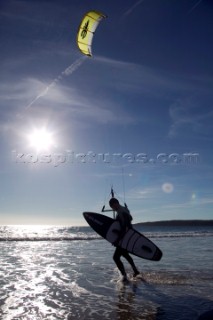 Kite surfer walking on a sandy beach in Tarifa, Spain, near Gibraltar.