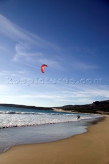 Kite surfer walking on a sandy beach in Tarifa, Spain, near Gibraltar.