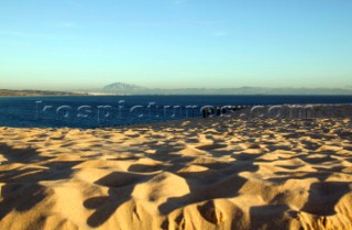 Sand dunes and fencing on a wind swept sandy beach in Tarifa, Spain, near Gibraltar.