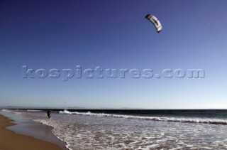 Kite surfer walking on a sandy beach in Tarifa, Spain, near Gibraltar.