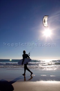 Kite surfer walking on a sandy beach in Tarifa, Spain, near Gibraltar.