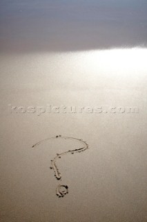 Question mark sign writing message on a sandy beach in Tarifa, Spain, near Gibraltar.