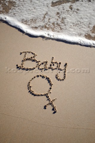 Baby girl sign writing message on a sandy beach in Tarifa Spain near Gibraltar