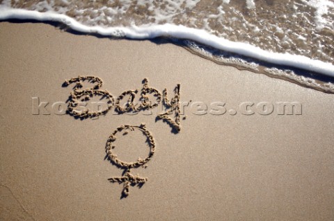 Baby girl sign writing message on a sandy beach in Tarifa Spain near Gibraltar