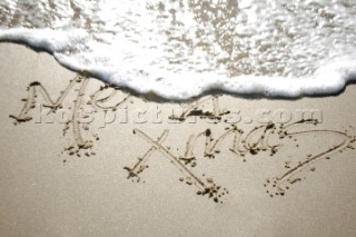 Merry Christmas Xmas sign writing message on a sandy beach in Tarifa, Spain, near Gibraltar.