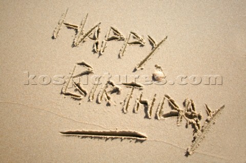 Happy Birthday sign writing message on a sandy beach in Tarifa Spain near Gibraltar