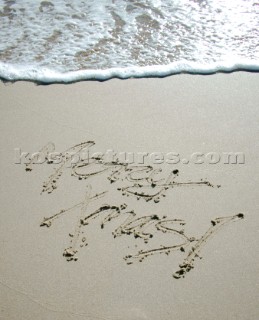 Merry Christmas Xmas sign writing message on a sandy beach in Tarifa, Spain, near Gibraltar.