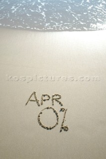 Zero percent APR 0% sign writing message on a sandy beach in Tarifa, Spain, near Gibraltar.