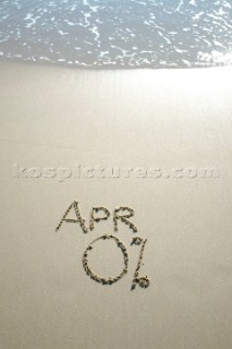 Zero percent APR 0% sign writing message on a sandy beach in Tarifa, Spain, near Gibraltar.