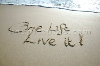 One Life - Live it sign writing message on a sandy beach in Tarifa, Spain, near Gibraltar.