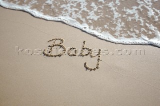 Baby boy congratulations sign writing message on a sandy beach in Tarifa, Spain, near Gibraltar.