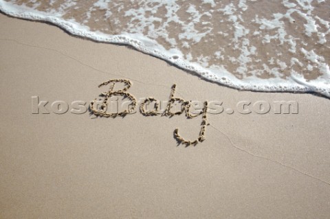 Baby boy congratulations sign writing message on a sandy beach in Tarifa Spain near Gibraltar