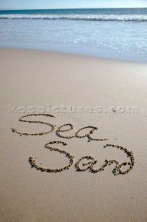 Sea Sand sign writing message on a sandy beach in Tarifa, Spain, near Gibraltar.