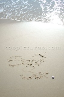 Sea Sand sign writing message on a sandy beach in Tarifa, Spain, near Gibraltar.